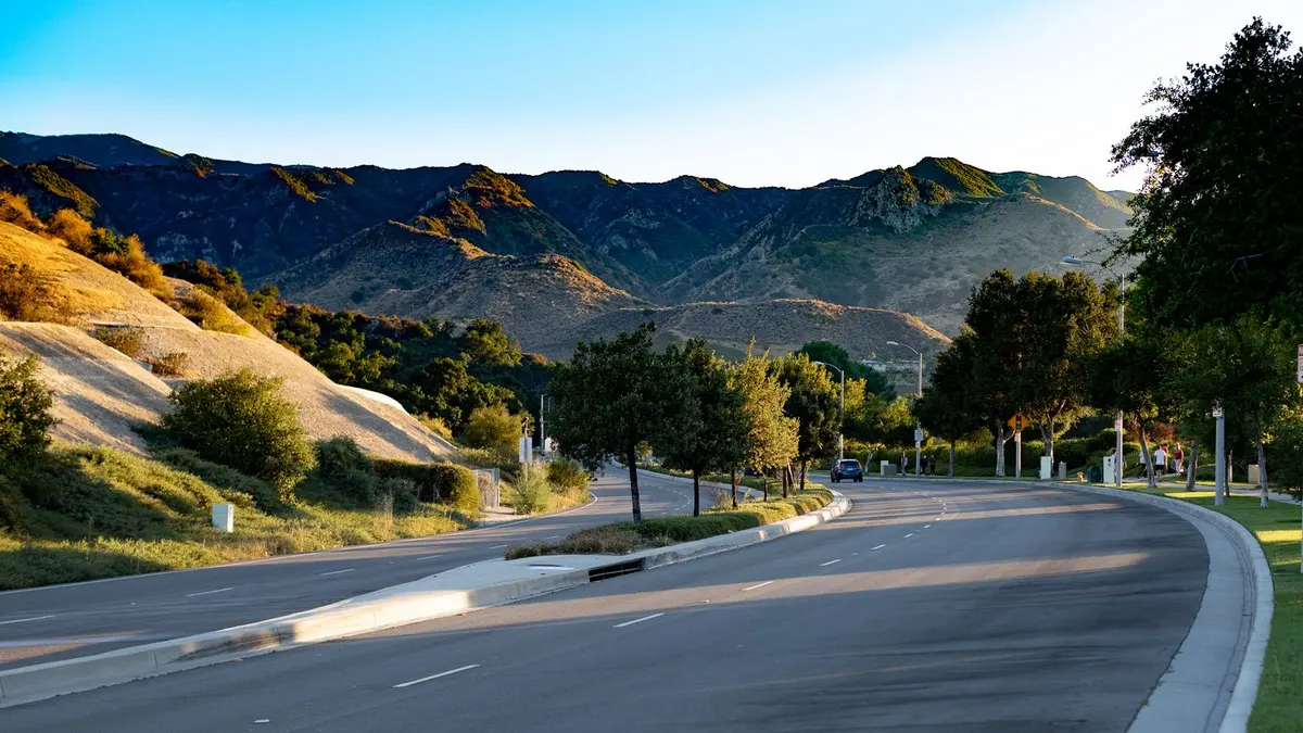 Empty highway winding through green hills