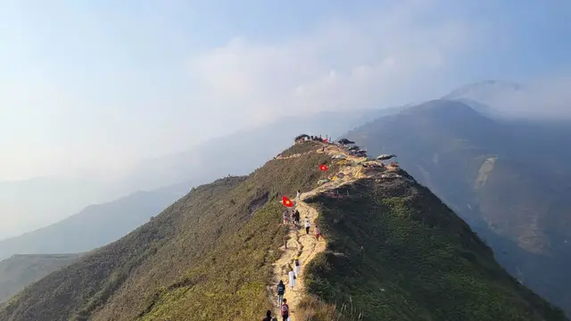 Hikers ascending a mountain ridge at sunrise