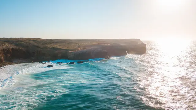 Bright sun shining over sea and cliffs